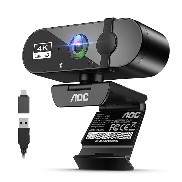 Webcam 4K AOC AC310 negra con tapa deslizante sobre el objetivo, inclinada hacia arriba en su pinza